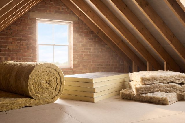 A neat arrangement in a sunlit British loft of three insulation types side by side: rolled mineral wool, rigid PIR board and natural wool batts