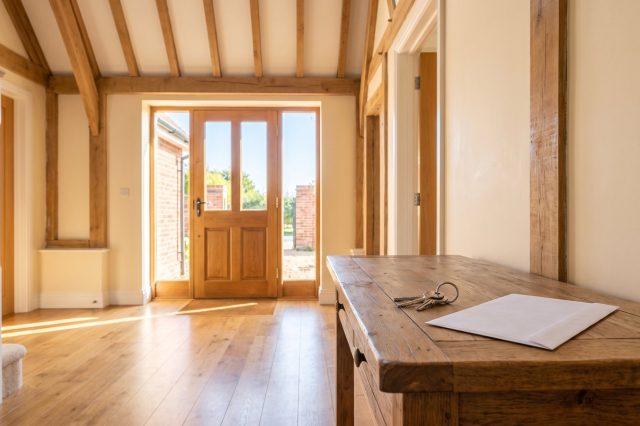 A British homeowner's sunlit hallway with a front door letting in bright daylight